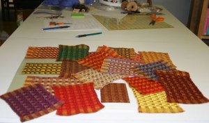 Photo of different color combinations made by changing weft colors on a brown and gold warp.  Handwven by Joanne Littler, Pine Ledge Fiber Studio, Fairfax, VT.