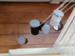 photo of 5 film cans hanging from the back of a loom used to try and fix broken warp threads during weaving